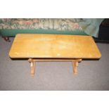 A light stained wood coffee table with canted rectangular top,