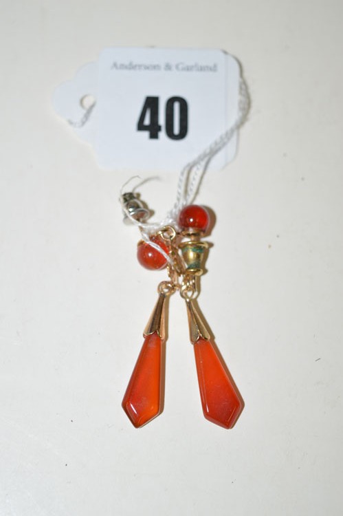 A pair of Chinese yellow metal and carnelian set drop earrings.