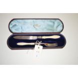 A presentation knife and fork with carved ivory handles and silver blade/prongs, by H.W. & Co.