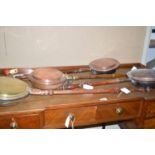 Four 19th Century copper and brass bed warming pans with turned wooden handles.