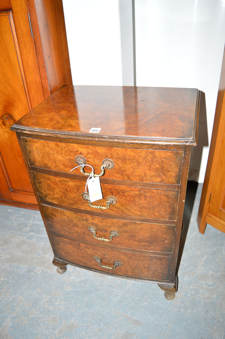 A burr walnut bedside table, the bowfront fitted four drawers with brass handles,