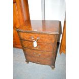 A burr walnut bedside table, the bowfront fitted four drawers with brass handles,