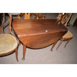 A George III oval mahogany drop-leaf dining table, raised on turned tapering legs and pad feet.