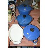 A set of three graduating blue enamelled Le Creuset casserole dishes and covers;