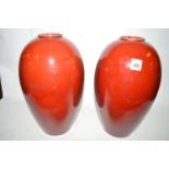 A pair of Bretby red glazed vases, one drilled for electricity.