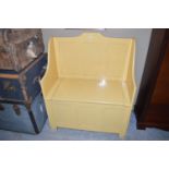 A yellow painted hall bench with lift-up lid,