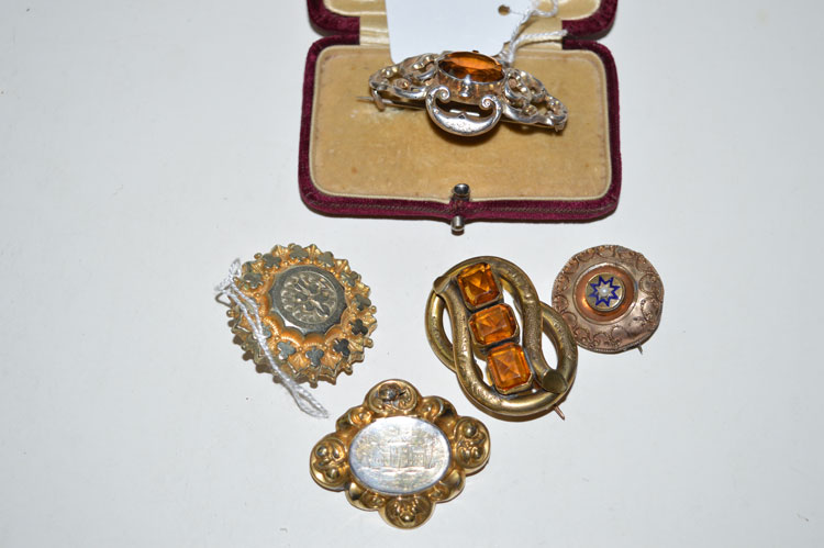 A quantity of 19th Century brooches, set with orange stones,