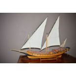 A wooden model of a two-masted sailing Dhow.