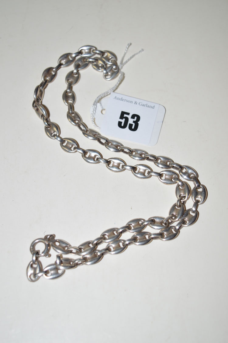 A silver necklace of button style and oval links.