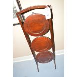 A three-tier folding mahogany cake stand.