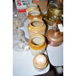 Four semi glazed stoneware storage jars; and another modern storage jar with 'Mustard' label.