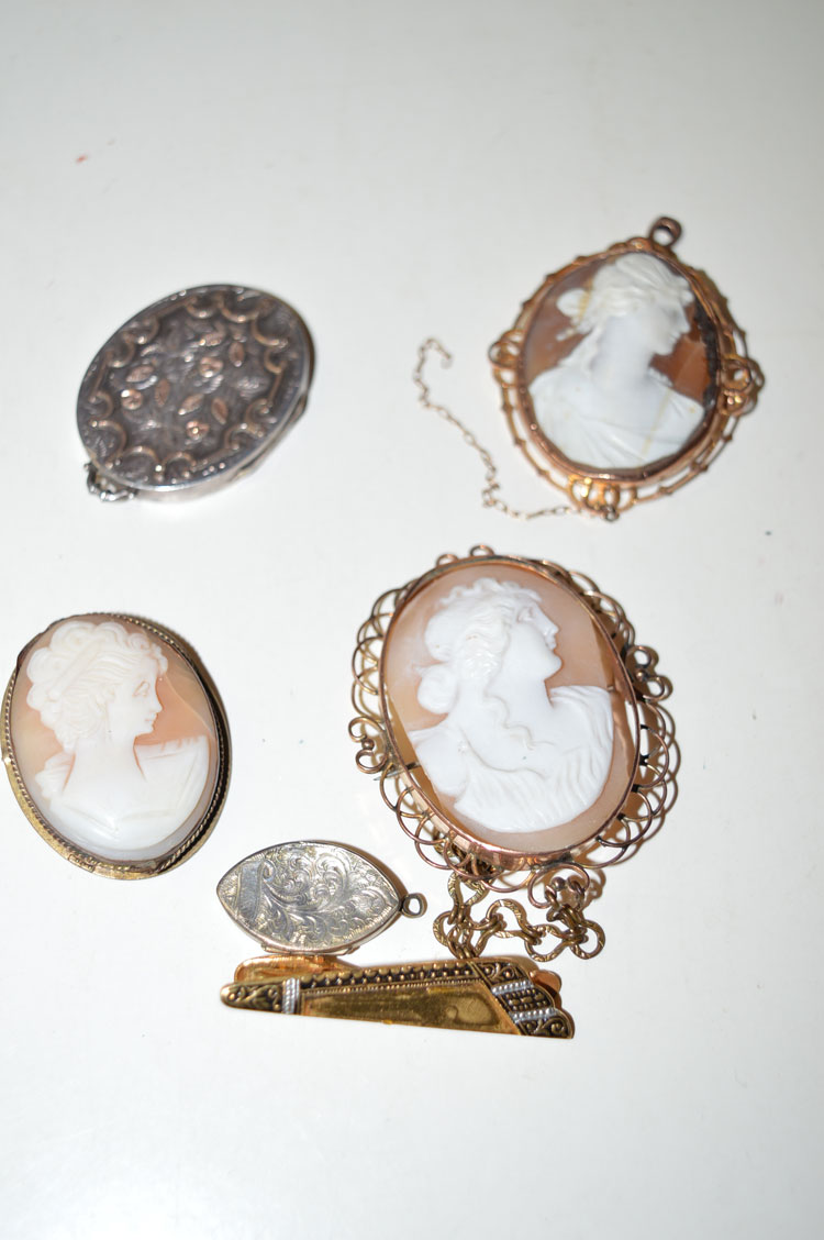 Three carved shell cameo brooches in gilt and yellow metal mounts; an oval and yellow metal locket;