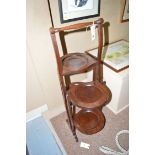 A mahogany double sided three-tier cake stand.