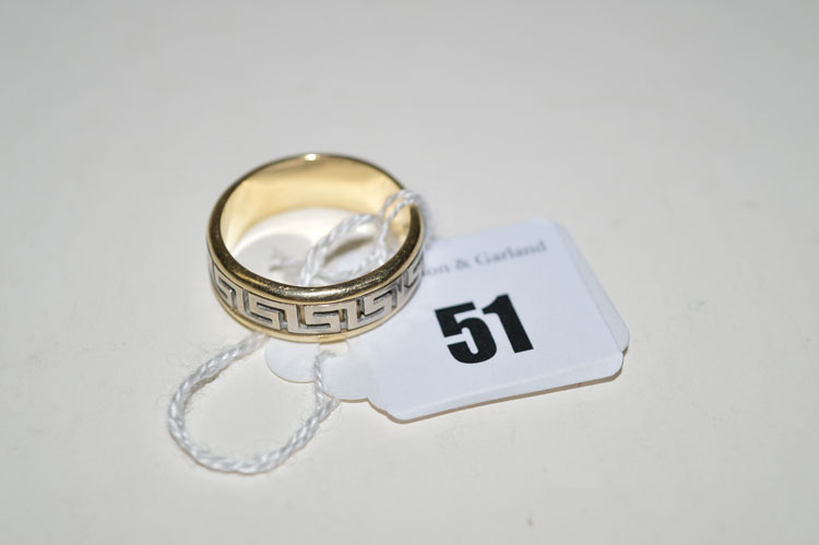 A white and yellow metal Greek key pattern ring, stamped '585', ring size T.