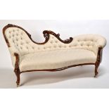A Victorian carved mahogany chaise longue, the shaped back and arms carved with leaf scrolls,