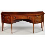 A George III mahogany breakfront sideboard, the shaped top above central frieze drawer,