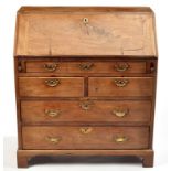 A George III mahogany bureau, the fall-flap enclosing pigeon holes and drawers,