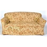 A Howard & Sons two seat sofa, the back, arms and seat upholstered in loose floral pattern material,