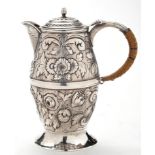 A George III hot water jug, by John Schofield, London 1783, ovoid with embossed foliate decoration,