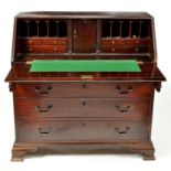 A George III mahogany bureau, the fall flap enclosing central cupboard door,