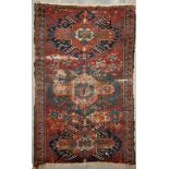 A Caucasian rug, with geometric medallions on a red border, 63 x 39in.