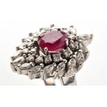 A ruby and diamond ring, the central oval facet cut ruby (probably synthetic),
