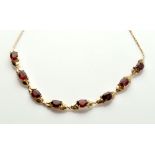 A garnet and yellow metal necklace,