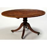 A Regency mahogany tip-up-top breakfast table, the oval top with crossbanded edge,