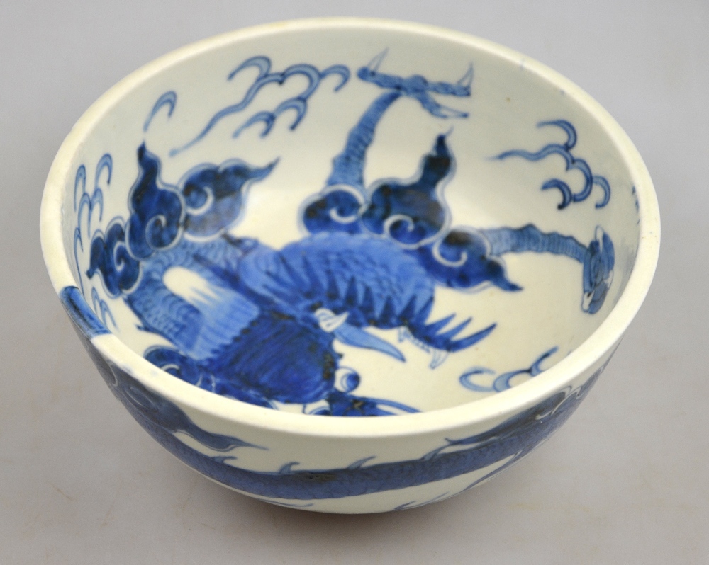 A Chinese 19th century heavily potted porcelain blue and white bowl decorated with a dragon