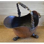 A Regency copper coal helmet, the Dolphin-cast swing handle with turned wood grip, on claw feet