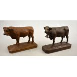 A Swiss Black Forest carved wood Bull and Cow with bell, inscribed beneath 'Davos 1933' and Gstaad