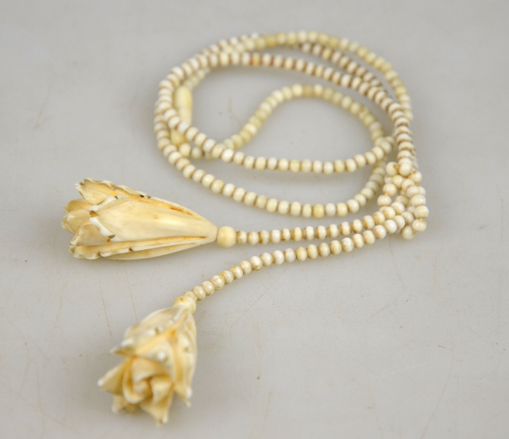 A necklace of small bone beads having carved flower terminations, screw in barrel snap