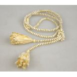 A necklace of small bone beads having carved flower terminations, screw in barrel snap