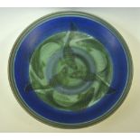 A Poole Pottery Studio circular dish decorated with a fish design by Sally Tuffin and painted by