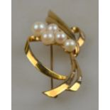 A 9ct yellow gold stylised bow brooch set with five cultured pearls