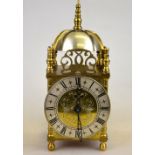 A 1930's brass mantel timepiece in the form of a lantern clock with silvered chapter ring, 25 cm