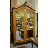 A French styled kingwood/walnut armoire, the domed top with carved surmount over a pair of bevel