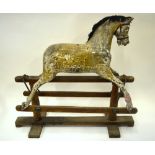 A Victorian wooden rocking horse with replacement mane and original leather bridle, vestigial paint,