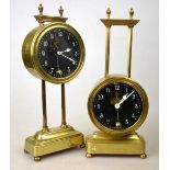 Two brass gravity clocks with glass dials and visible pendulums and escapements, 26 cm One not