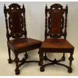 A pair of 19th century continental carved oak hall chairs with original battered red leather