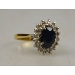 An oval sapphire and diamond cluster ring, white and yellow gold set stamped 18ct Condition Report