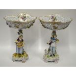 A pair of porcelain Potschappel comports, the reticulated bowls painted with polychrome flowers to