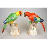 A pair of Dresden models of parrots, each perched on a tree trunk, 20th century, 19.5 cm h. (2)