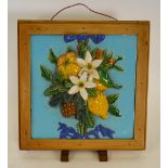 A Victorian Minton Majolica tile moulded in relief with a garland of mixed fruit and flowers tied