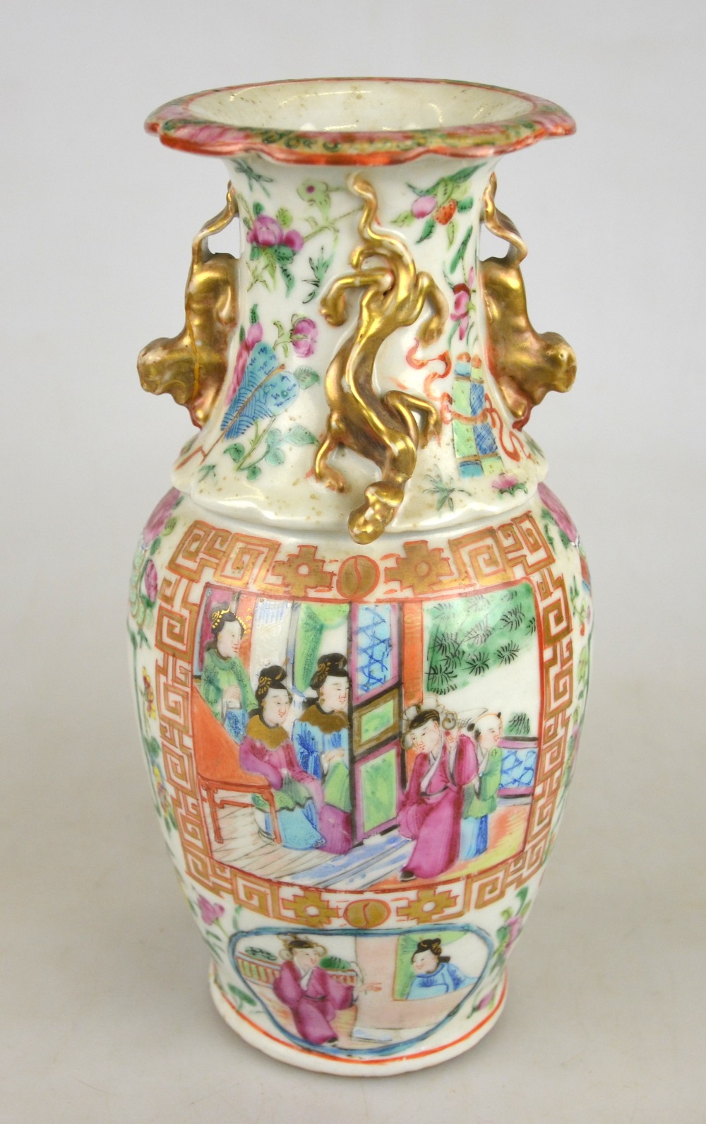 A Chinese Canton famille rose baluster vase decorated with panels of figures on a verandah and