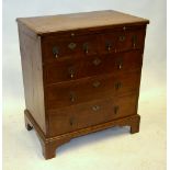 A small 19th century feather-banded walnut chest comprising a slide over two short and three long