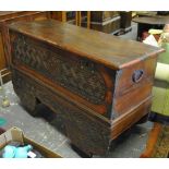 A large carved teak trunk on trolley whe