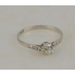 A single stone old cut diamond ring having three eight-cut diamonds on each shoulder, white metal