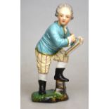 A 19th century Horchst porcelain figure of a young scribe standing on a naturalistic base,