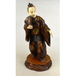 A Japanese carved wood standing figure of a man holding a fan, his robe gilt lacquered and inlaid